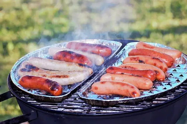 Cooking sausages on a camping grill