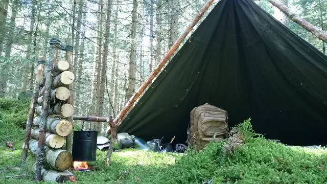 Tent in the woods set up in a primitive-camping style